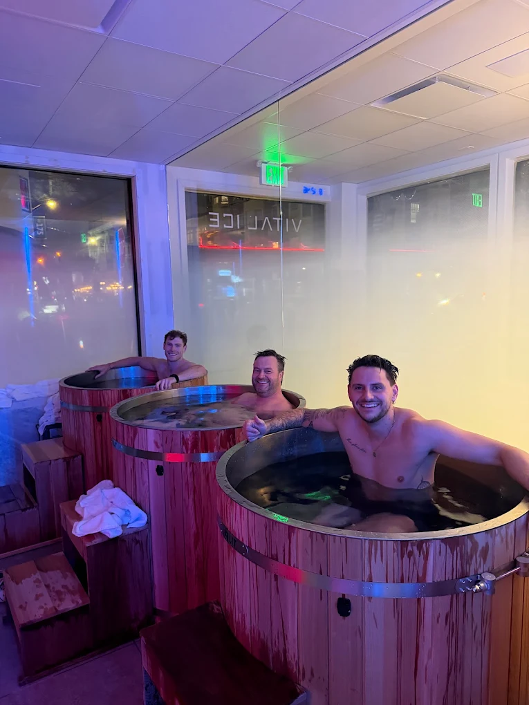 Three members smiling in cedar cold plunge tubs